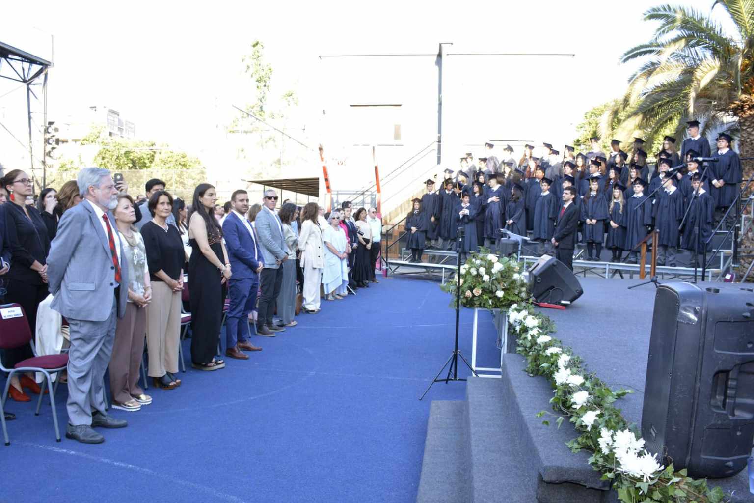 Graduados del Colegio TEI con toga junto a autoridades e invitados en la ceremonia de graduación