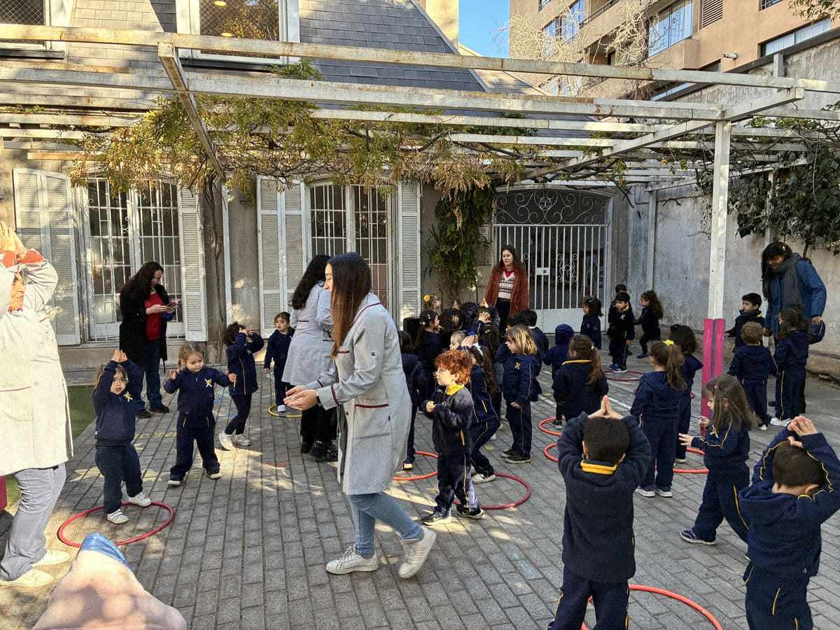 Niños de Junior School del Colegio TEI bailando con su profesora en el patio