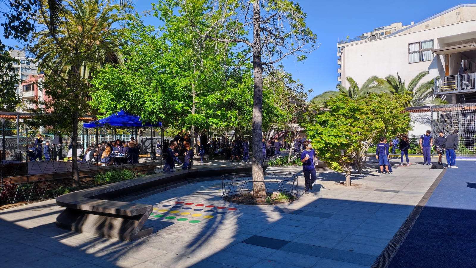 Patio central del Colegio TEI con árboles y estudiantes, imagen de la página de Admisión