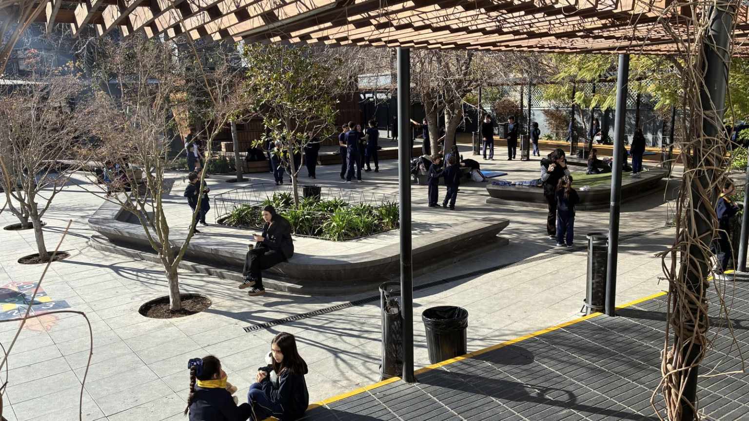 Estudiantes del Colegio TEI en el patio con pérgola y árboles
