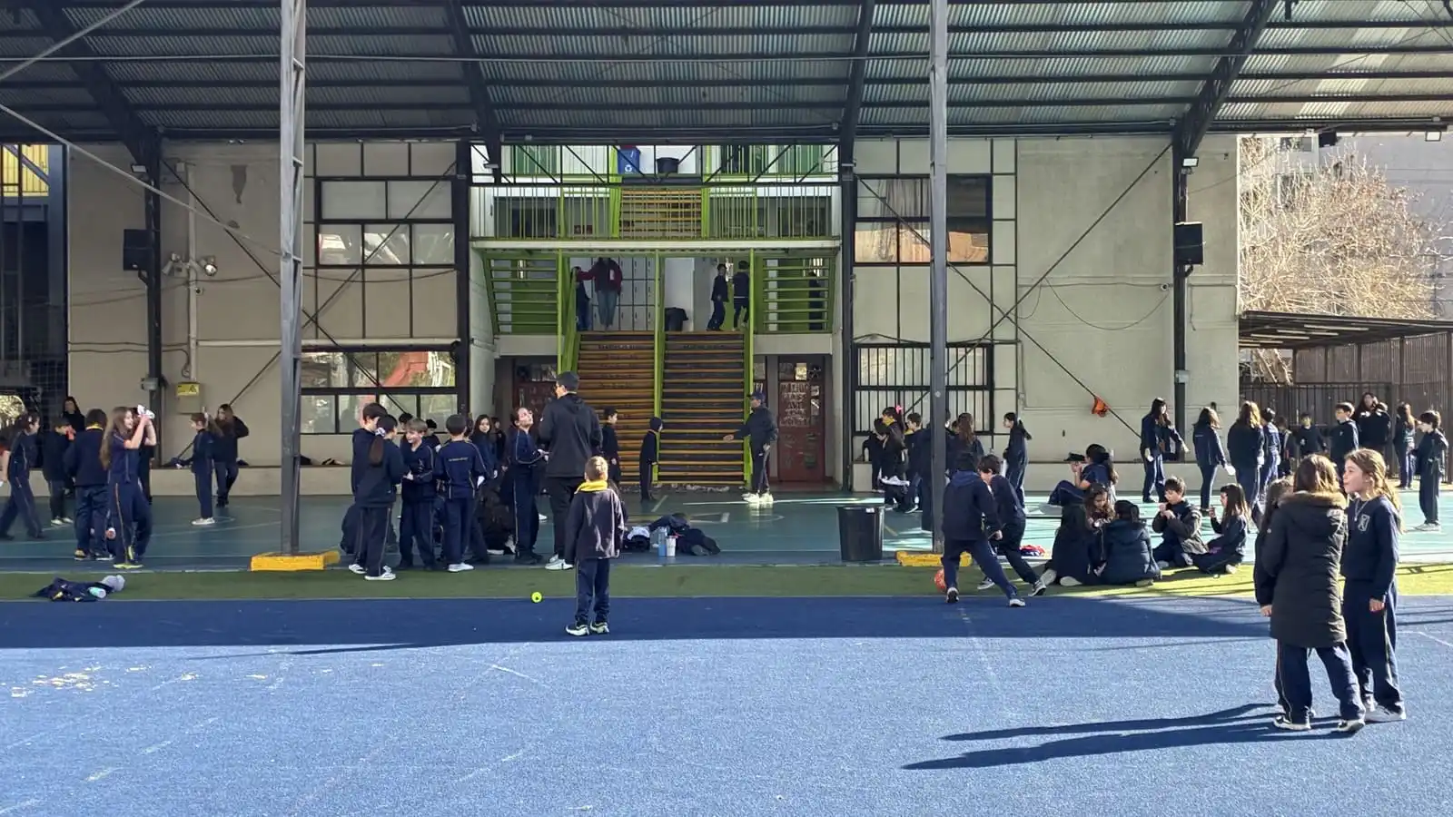 Estudiantes del Colegio TEI reunidos en el gimnasio techado con cancha azul