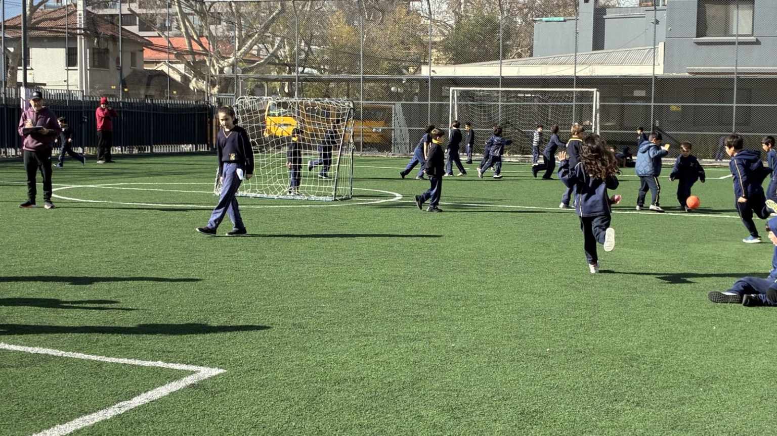 Estudiantes del Colegio TEI jugando fútbol en la cancha de pasto sintético