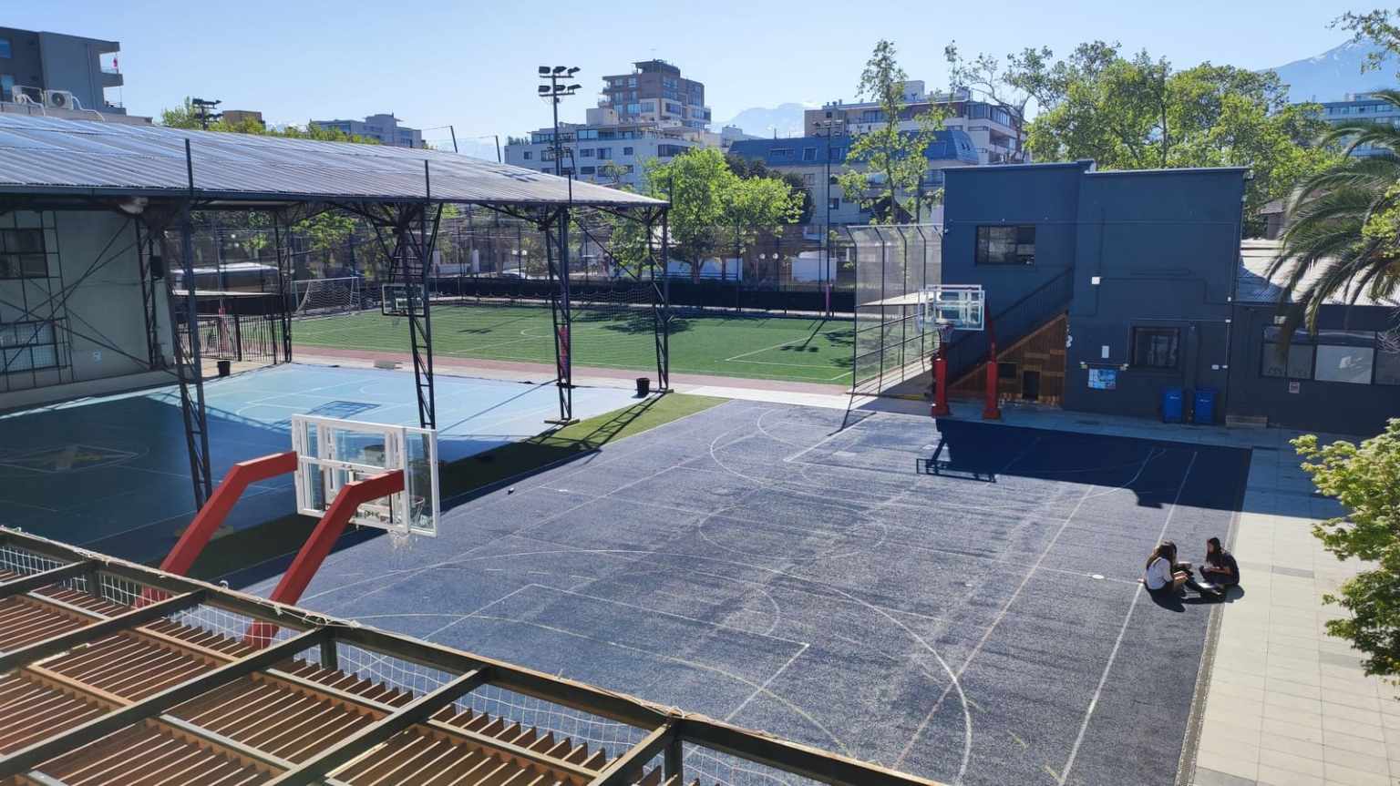 Vista elevada de la multicancha de básquetbol y la cancha de fútbol de pasto sintético del Colegio TEI